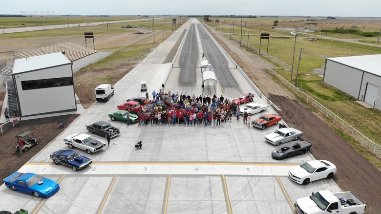 Eine Draufsicht auf die neue SCRA Dragstrip-Strecke, während die Streckenarbeiter und unterstützenden Gemeindemitglieder das Band für die Eröffnung durchschneiden.