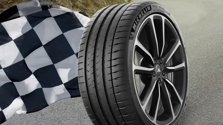 3/4-Ansicht eines Michelin Pilot Sport 4 S-Reifens auf einer Felge mit einer Zielflagge auf der linken Seite
