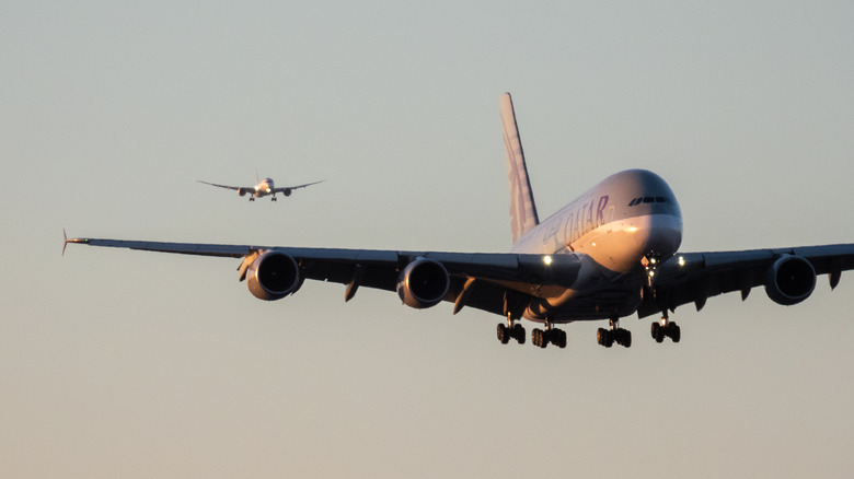 Ein Airbus A380 von Qatar Airways landet zur Landung, direkt dahinter eine Boeing 787 von Qantas