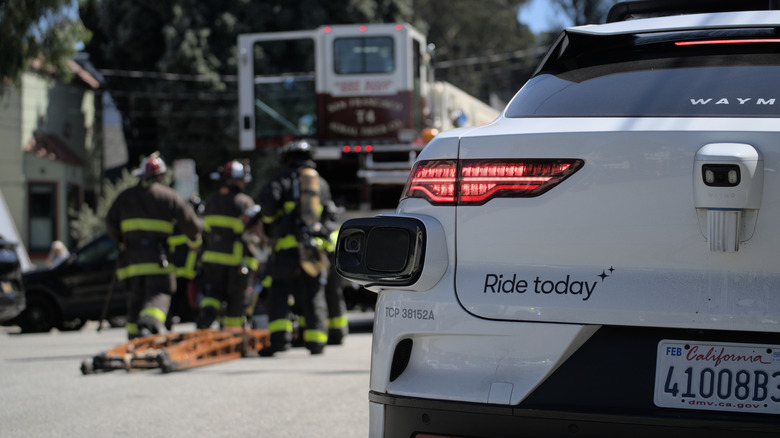 Ein Waymo-Auto nähert sich dem Notfallort, während die Feuerwehr eingreift.