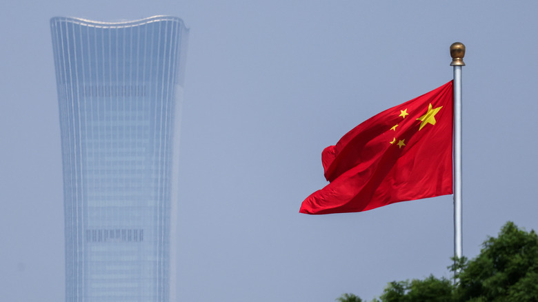 Der Citic Tower an einem diesigen Tag, mit der chinesischen Flagge im Vordergrund