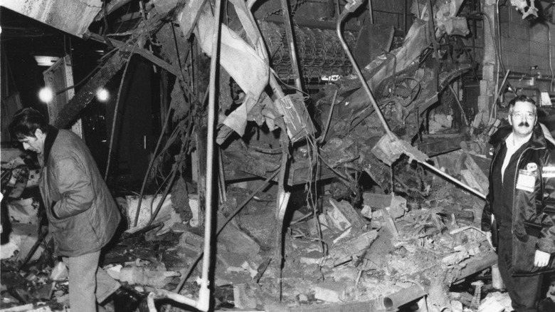 Zwei unbekannte Männer untersuchen Bombenschäden in der Nähe eines Schließfachbereichs im Gepäckausgabeterminal am LaGuardia Airport, New York, New York, 29. Dezember 1975. Die Bombe tötete 11 Menschen und verletzte mehr als 70 weitere.