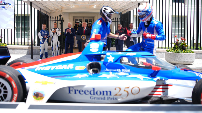 WASHINGTON, DC – 13. JULI: US-Präsident Donald Trump spricht, während Felix Rosenqvist, Sieger des Indianapolis 500 von 2026, Alex Palou, der amtierende Champion der IndyCar-Serie, und Bud Denker, Vorsitzender des Freedom 250 Grand Prix, am 13. Juli 2026 in Washington, DC bei einer Freedom 250 Grand Prix-Show auf der West Executive Avenue zwischen dem Westflügel des Weißen Hauses und dem Eisenhower Executive Office Building zuschauen. Das Grand-Prix-Autorennen IndyCar Freedom 250 am 22. und 23. August auf der National Mall ist Teil der Feierlichkeiten zum 250-jährigen Jubiläum der USA. (Foto von Andrew Harnik/Getty Images)