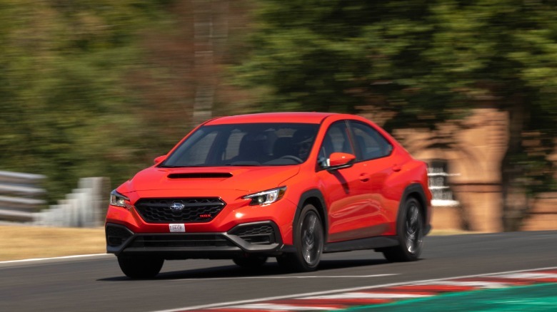 Eine Dreiviertelaufnahme von vorn eines roten WRX, der im Oulton Park an Bäumen vorbeifährt