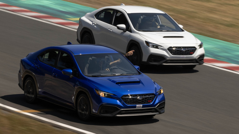 Eine Draufsicht eines blauen WRX, der auf der Rennstrecke einen weißen WRX vorbeiführt