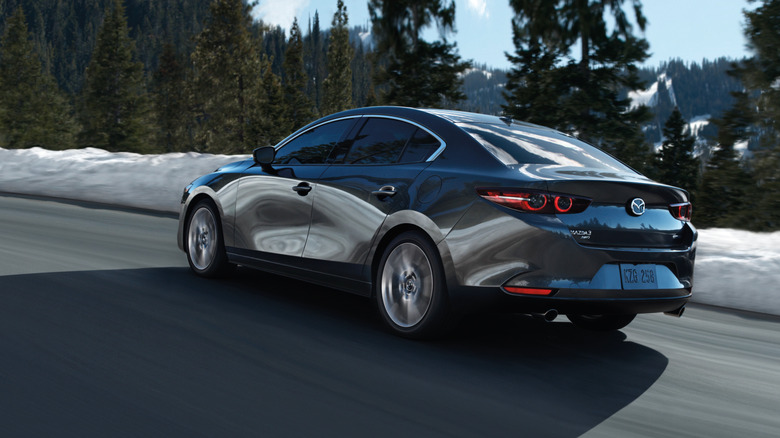 3/4-Hinteransicht einer grauen Mazda 3-Limousine, Baujahr 2026.