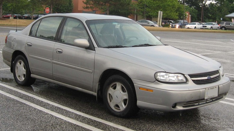 Der seelenlose Chevrolet Malibu der fünften Generation in noch seelenloserem Silber auf einem Parkplatz.