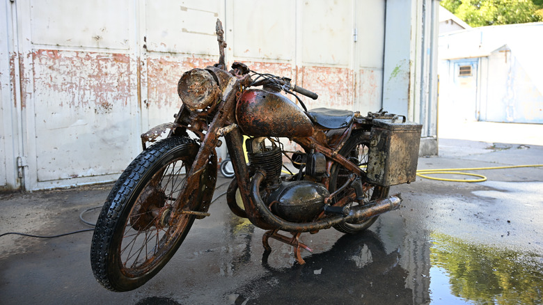 Ein aufgeräumtes, altes Kriegsfahrrad, noch nass vom Waschen in einer gut beleuchteten Garage.