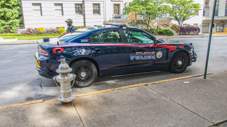 Atlanta, Georgia, USA – 06.07.20: Seitenansicht des Polizeiautos der Innenstadt von Atlanta und Beamter an der Seite