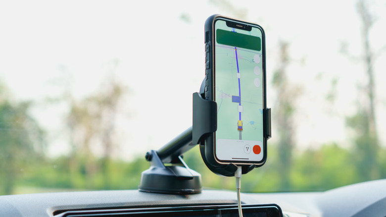 Ein Telefon mit einer Navigations-App in einer Halterung am Armaturenbrett eines Autos