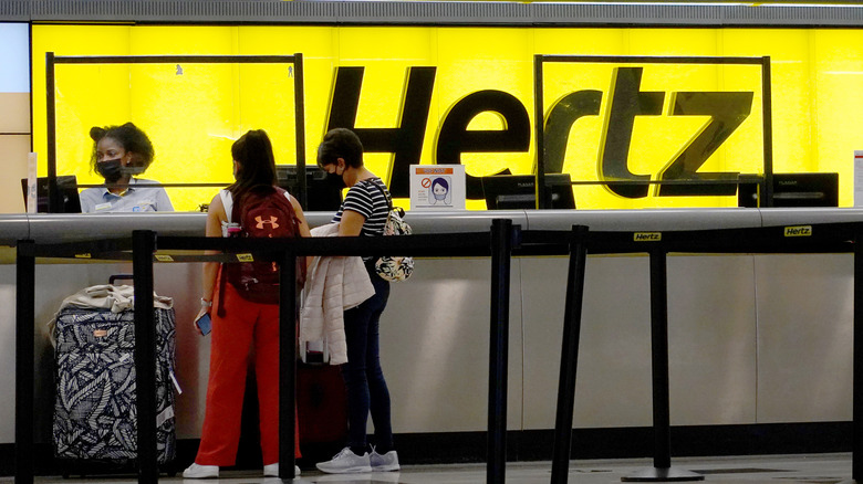 MIAMI, FLORIDA – 25. OKTOBER: Am 25. Oktober 2021 in Miami, Florida, mieten Menschen Autos an einem Hertz-Autovermietungsschalter am Miami International Airport. Hertz gab bekannt, dass es 100.000 Teslas bestellt habe, da das Unternehmen gerade aus der Insolvenz komme.