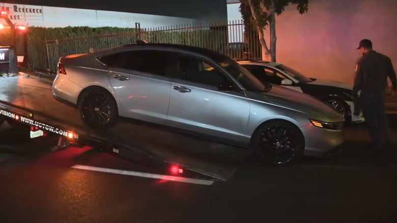Eines der 200 Fahrzeuge, die bei der Straßenübernahme abgeschleppt und beschlagnahmt werden sollen, eine silberne Limousine mit getönter Farbe und schwarzen Rädern, wird auf einer flachen Anhängerkupplung abgestellt.