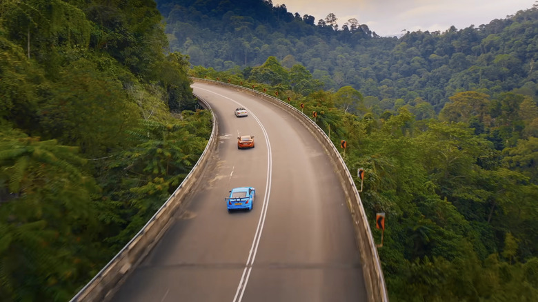 Screenshot von „The Grand Tour“ mit drei günstigen Sportwagen, die durch Malaysia fahren.