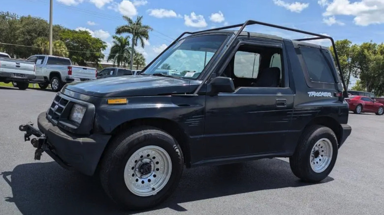 Ein schwarzer Chevrolet Tracker von 1998 auf einem Parkplatz, leicht schräg fotografiert.