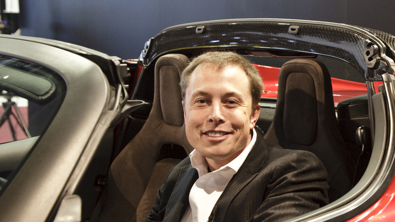 Elon Musk sitzt in einem originalen Tesla Roadster