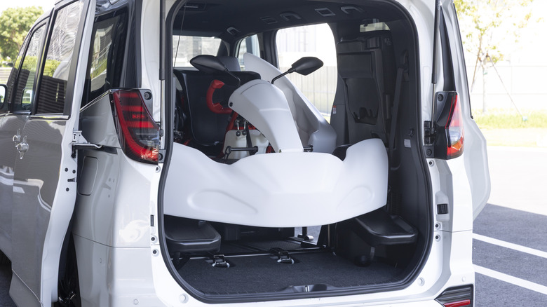 Ein weißer Toyota GR Kart im Heck eines weißen Toyota Noah
