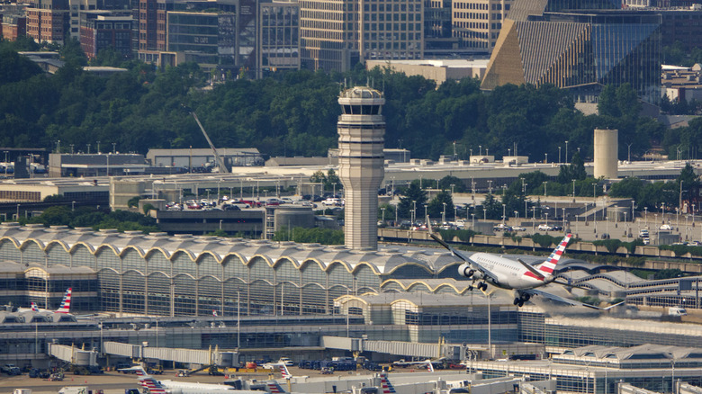 Ein Flugzeug fliegt auf die Landebahn in der Nähe des Flugkontrollturms des Ronald Reagan Washington National Airport zu.