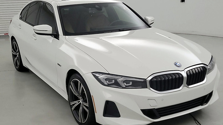 Weißer 2023 BMW 330 Plug-in-Hybrid, geparkt in einem leeren Raum