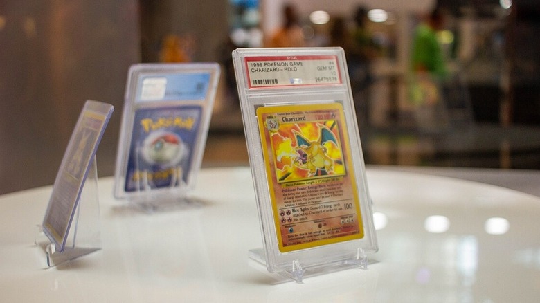 Eine Glurak-Pokémon-Karte der ersten Generation, verpackt und auf einem Tisch auf der New York Comic Con 2021 ausgestellt.