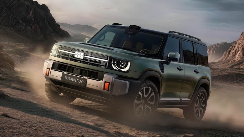 Vorne 3/4 eines grünen Geely Battleship 700 SUV, der auf einer unbefestigten Straße fährt