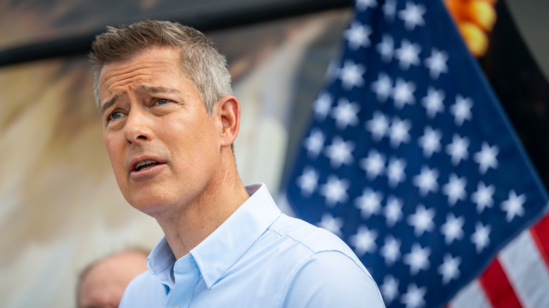US-Verkehrsminister Sean Duffy sieht verwirrt aus, als er irgendwo während einer Rede vor einer amerikanischen Flagge steht.