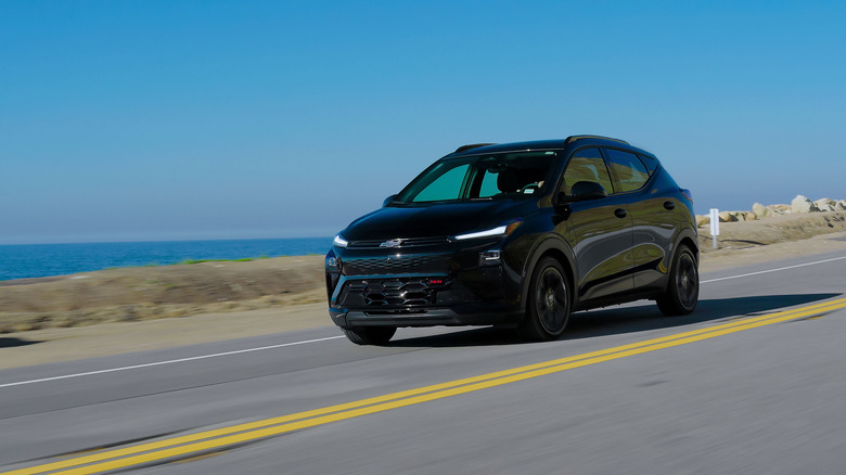 Vordere 3/4-Ansicht eines schwarzen 2027 Chevrolet Bolt in Bewegung.