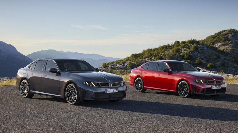 Vordere 3/4-Ansicht eines grauen 2027 BMW 330 und eines roten 2027 BMW M350