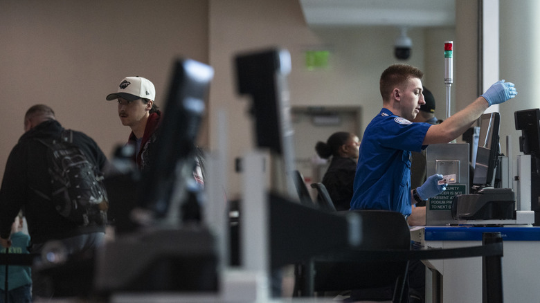 MINNEAPOLIS, MINNESOTA – 23. MÄRZ: Ein TSA-Agent überprüft Reisende in Minneapolis-St. Paul International Airport Terminal 2 am 23. März 2026 in Minneapolis, Minnesota. Es kommt weiterhin zu Reiseunterbrechungen, da Hunderte von TSA-Agenten während eines teilweisen Regierungsstillstands kündigen oder unbezahlt arbeiten. US-Präsident Donald Trump sagte, am Montag würden ICE-Agenten auf US-Flughäfen stationiert, wobei Grenzzar Tom Homan für die Bemühungen verantwortlich sei. (Foto von Stephen Maturen/Getty Images)