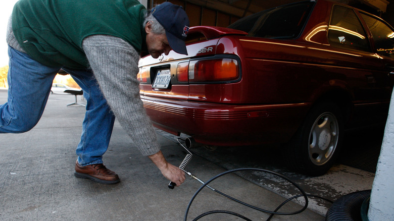 SAN RAFAEL, CA – 12. DEZEMBER: Alex Gromov steckt eine Sonde in das Auspuffrohr eines Autos, während er am 12. Dezember 2007 in San Rafael, Kalifornien, einen Smog-Check bei Marinwood Smog Check durchführt. Bundesbezirksrichter Anthony W. Ishii bestätigte ein kalifornisches Gesetz aus dem Jahr 2002, das die Treibhausgasemissionen von Pkw und Lkw regelt. Dieser Schritt würde die Automobilhersteller dazu zwingen, den durchschnittlichen Kraftstoffverbrauch ihrer Flotten bis 2016 um etwa 30 Prozent zu steigern. Ein ähnlicher Gesetzentwurf, der im Kongress anhängig ist, würde eine Erhöhung der Kilometerleistung um 40 Prozent bis 2020 erfordern. (Foto von Justin Sullivan/Getty Images)