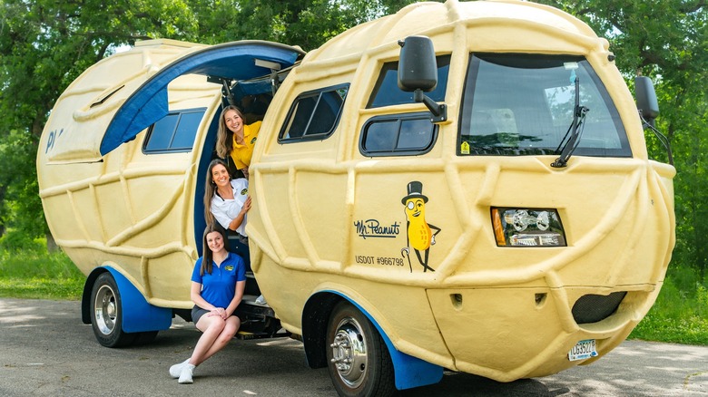 Das NUTmobile mit geöffneter Seitentür und den drei aktuellen Peanutters, die auf der Treppe zum Führerhaus sitzen