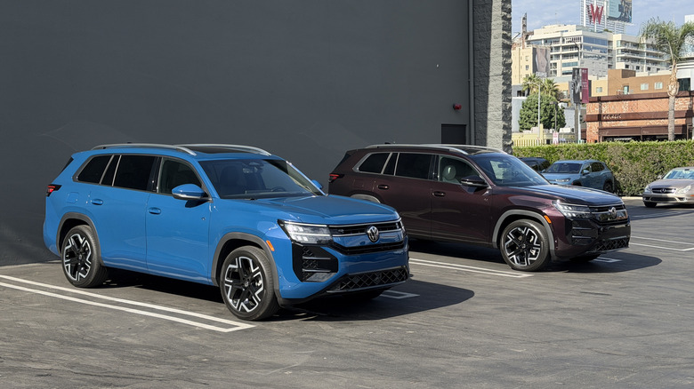 Zwei nebeneinander geparkte Volkswagen Atlas, einer blau und einer lila