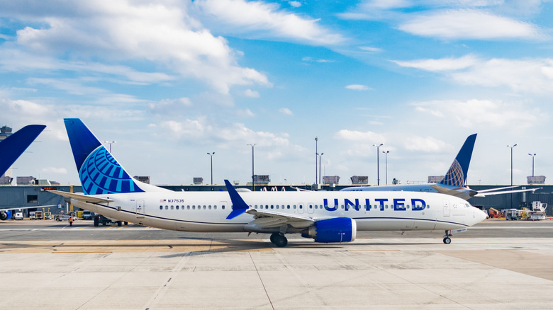 Abflug eines Flugzeugs der United Airlines am Flughafen. Flughafenterminal. Flugzeugankunft der Fluggesellschaft United. Abflug und Ankunft am Flughafen. Flugzeugterminalbereich.