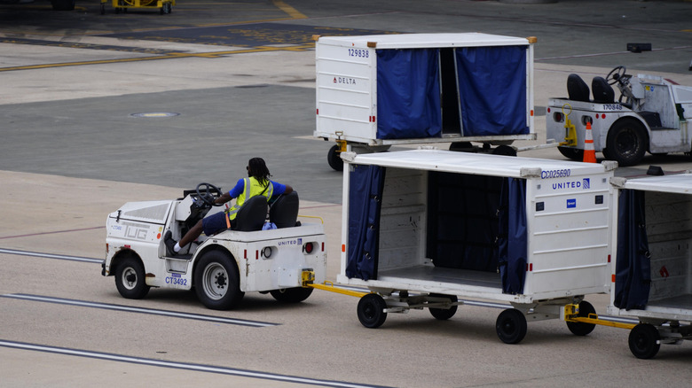Morrisville, North Carolina – 16. August 2026: Gepäckwagen am Flughafen fährt durch eine Halle auf dem Rollfeld des Flughafens