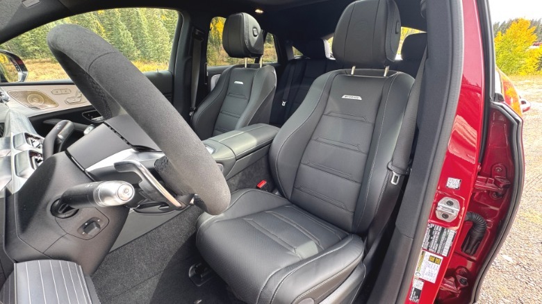 Ein Blick durch die offene Fahrertür zurück auf den schwarzen Fahrersitz im roten GLE53 Coupé mit gelben Bäumen im Hintergrund