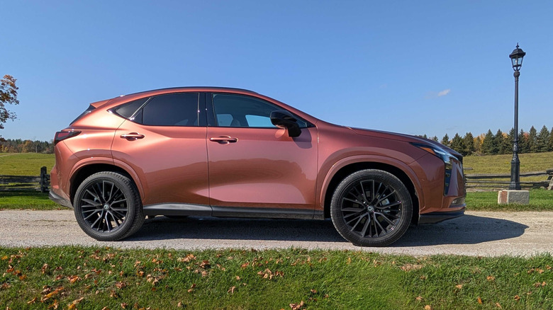 Seitenansicht eines 2027 Lexus NX in Kupfer, der auf einer ländlichen Einfahrt in Ontario geparkt ist.