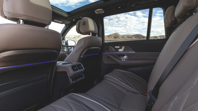 Ein Blick in die hintere Fahrertür des GLS63 auf den braunen Innenraum mit wolkenverhangenem blauen Himmel, der durch die Fenster und das Schiebedach sichtbar ist