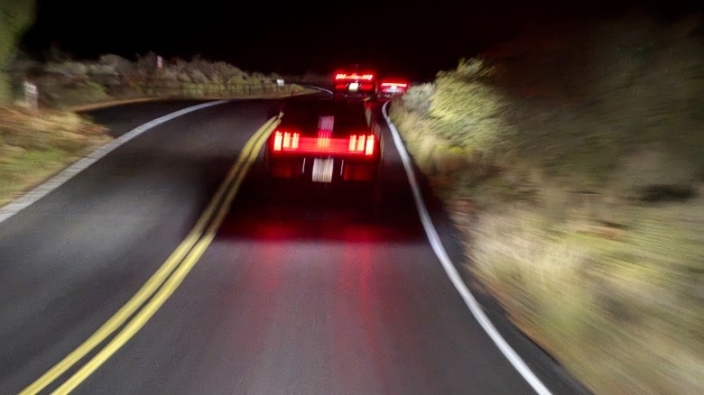 Verschwommenes Foto aus der Windschutzscheibe eines Q9 mit seinen Matrixscheinwerfern, das einen dunklen Fleck um die führenden Autos zeigt, der Rest der Sicht jedoch beleuchtet ist